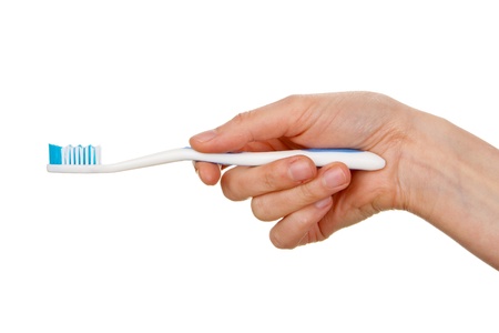 Woman's hand holding toothbrush isolated on white の写真素材