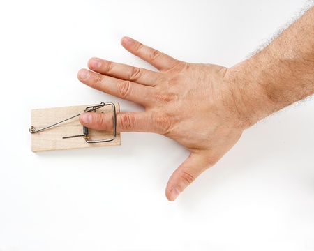 Male finger caught by mouse trap on white backgroundの写真素材