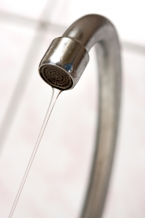 Water tap with flowing water  Selective focus, shallow depth of field の写真素材