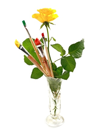Rose and paintbrushes in glass vase isolated on white backgroundの写真素材