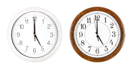 Two clock faces showing five o'clock isolated on whiteの写真素材