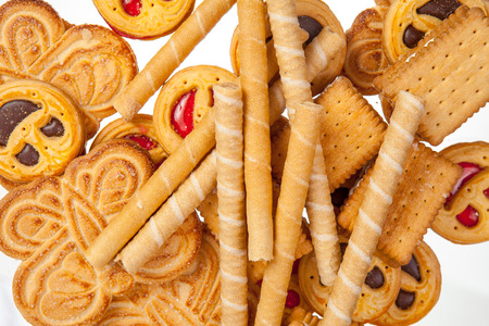 Round cookies with smiling faces, sweet tubules, butterfly and sandwich cookies background