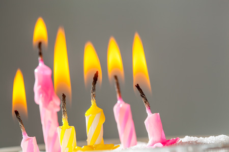 Six burning  birthday candles over grey background. Selective focus, shallow depth of fieldの写真素材