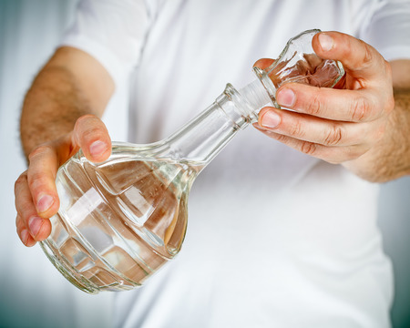 Carafe in hands of male in white t-shirtの写真素材