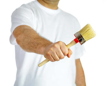 Paint brush in hand of a man in white t-shirtの写真素材