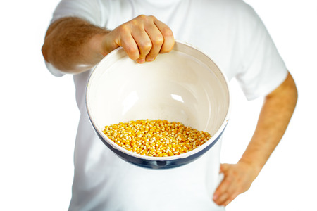 Man holding a bowl of corn grain with one hand. Shallow depth of fieldの写真素材