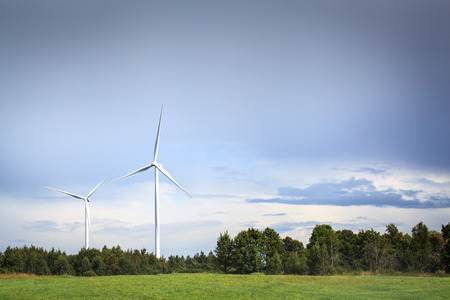 White wind turbines against blue sky