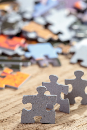 Three jigsaw puzzle pieces on a tableの写真素材