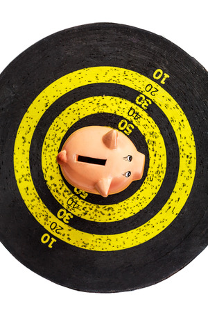 Saving concept: piggy bank on old yellow target boardの写真素材