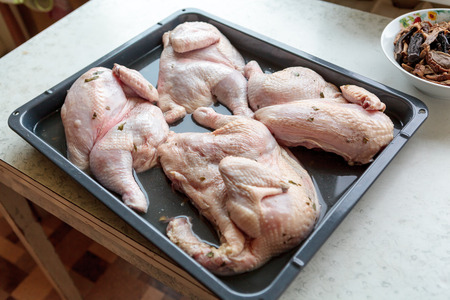 Chicken halfs prepared for cooking on trayの写真素材