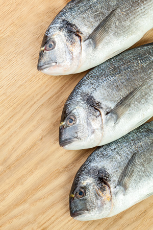 Three dorado fishes on wood boardの写真素材