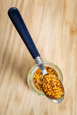 Wholegrain mustard spoon on glass jar. View from topの写真素材
