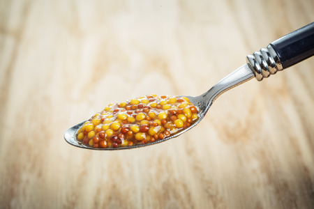 Wholegrain mustard spoon wooden backgroundの写真素材