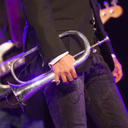 Musician hand holding trumpet on stageの写真素材