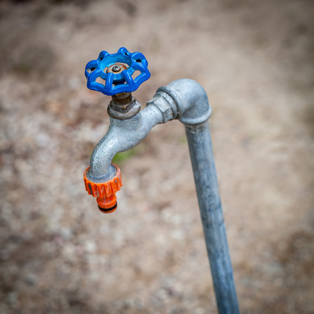 Outdoor water tap over blurry background. Shallow depth of fieldの写真素材