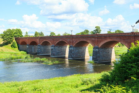 KULDIGA; LATVIA - July 05; 2017: Old brick bridge across the Venta - built in 1874 and one of the longest its type in Europe.の写真素材