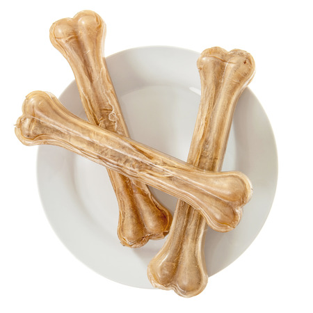 Three dog bones on plate isolated over whiteの写真素材
