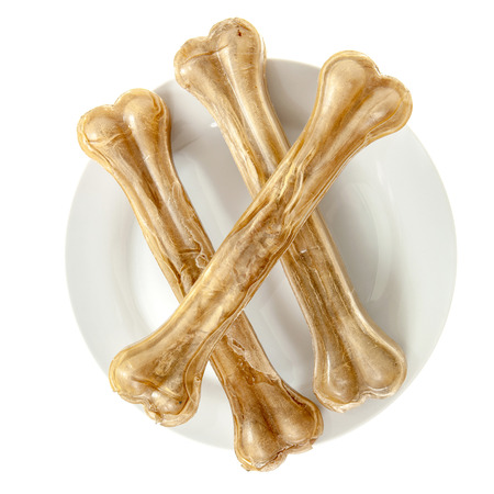 Three dog bones on white plate isolatedの写真素材
