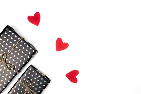 Gift boxes wrapped in black paper with hearts flat lay on white background with copy space. 8 march, Mother's day, Valentine's Day gifts top view. Celebrate concept. Template for web, social media.の写真素材