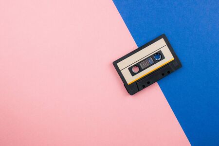 Retro audio cassette flat lay on colorful blue pink pastel background. Top view with copy space. Creative fashion design in minimal 80-s style with duotones. Music, radio, dj concept. Template for webの写真素材