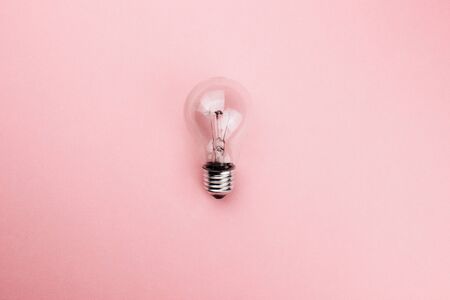 Glass transparent lightbulb flat lay on colorful pink background. Top view copy space. Creative fashion design in minimal style. Ecology, energy power, idea concept. Template for web. Stock photo.の写真素材