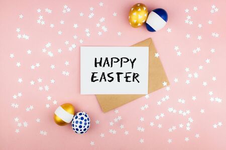 Golden blue spring easter eggs, envelope and letter with happy easter phrase stars confetti flat lay on colorful pink background top view copy space. Easter celebration concept template. Stock photo.の写真素材