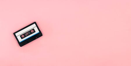 Retro audio cassette tape flat lay on colorful pink background top view with copy space. Creative fashion design in minimal retro 80-s style. Music, radio, dj concept. Web banner template. Stock photoの写真素材