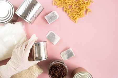 Quarantine isolation period food flat lay on pink background copy space. Sugar, rice, pasta, tea,...