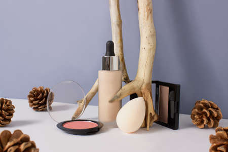 Set of makeup professional products on blue background. Composition with foundation, eyeshadows,...