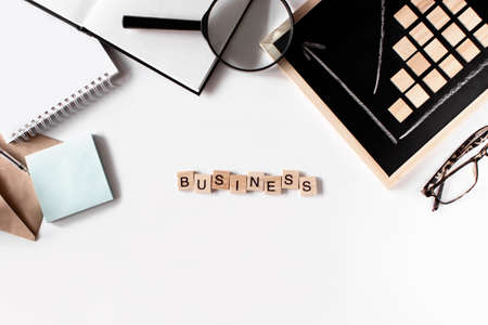 Business flat lay on white background top view. Word business made of wooden letters. Envelope,...