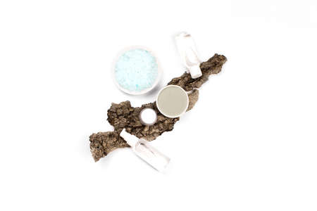 Sea salt with skincare product on tree bark isolated on white