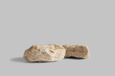 Beige marble rock pedestals on gray background with copy space, side view. Podium mockup for...