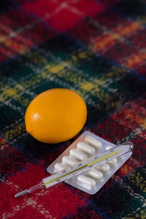 Thermometer, pills and lemon on woolen blanketsの写真素材