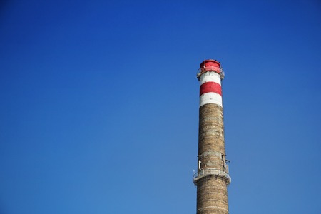 Brick chimney against a blue sky, clear blue sky, mobile communications equipment, black crow on the...