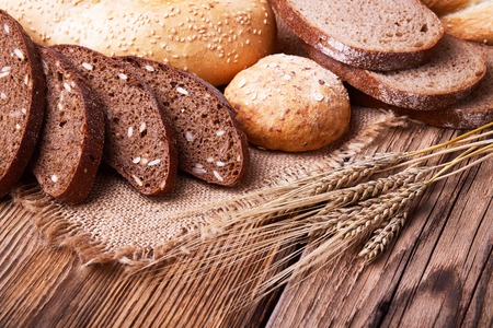 Fresh bread, sweet pastries, ears of ripe wheat, baked goods, harvest on the farm, great food, lots of baked goods, healthy food, a table of old wood, close-up bread, wood grainの写真素材