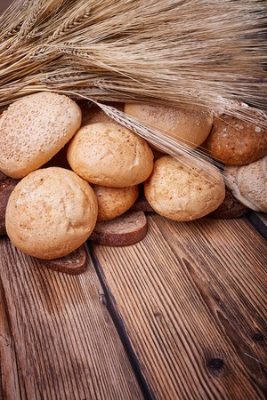 Fresh bread, sweet pastries, baked goods, harvest on the farm, great food, lots of baked goods, healthy food, a table of old wood, close-up bread, wood grainの写真素材