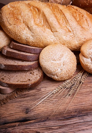 Fresh bread, sweet pastries, baked goods, harvest on the farm, great food, ears of wheat, burlap sack of grain, healthy food, a table of old wood, bread closeupの写真素材