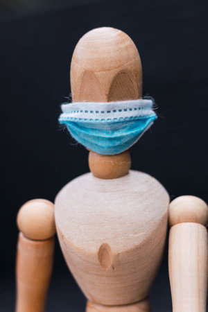 articulated wooden mannequin with blue mask