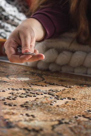 woman on the couch at home putting together a puzzle