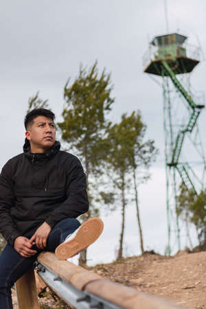 young man in the mountain in a black jacket smiling