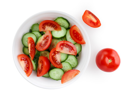 Sliced tomatoes and cucumbers on a white plate.の写真素材