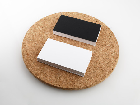 Black and white business cards on a round cork base.の写真素材