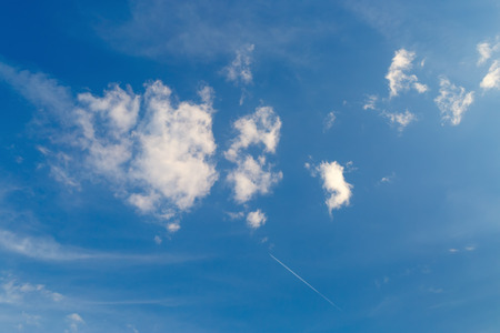 Blue sky with a few white cumulus clouds.の写真素材
