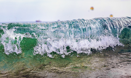 Wave with splashes closeup. Shallow depth of field.の写真素材