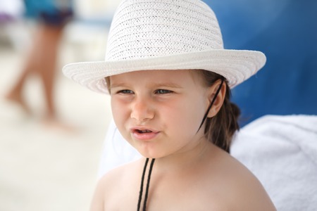 Portrait of a baby in a white hat on a bright sunny day closeup. Shallow depth of field. Focus on...