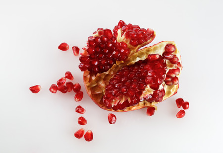 Part of delicious juicy ripe pomegranate and pomegranate seeds scattered around. Studio shot. Top view.の写真素材
