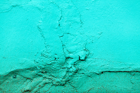 Fragment of the old wall, painted bright turquoise paint, cracked over time.の写真素材