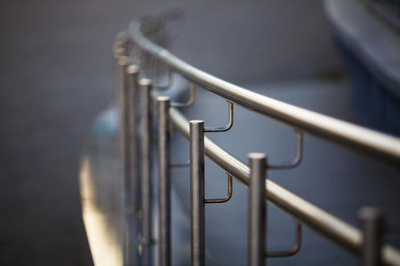 Chromium metal fence with handrail. Shallow depth of field. Selective focus.の写真素材