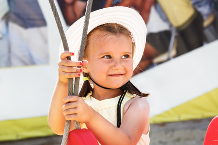 Sweet happy smiling little girl in white hat. Selective focus on child's face.の写真素材