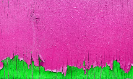 Peeling pink and green paint on wooden wall. Bright background with peeling paint.の写真素材
